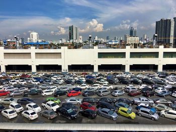 High angle view of cars at parking lot in city against sky