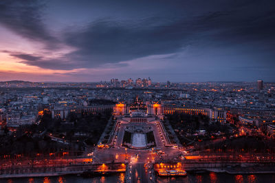 Illuminated buildings in city at sunset