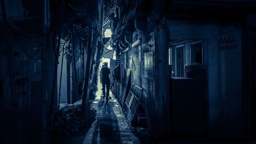 Narrow alley amidst houses at night