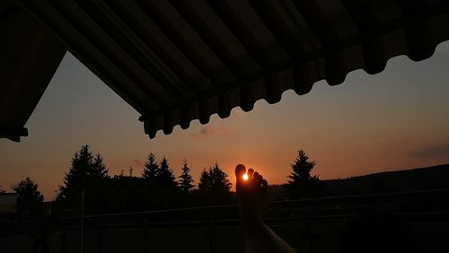 Silhouette of roof against sky during sunset