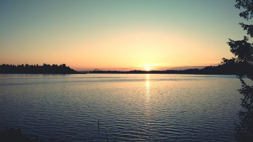 Scenic view of lake against clear sky during sunset