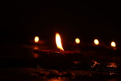 Close-up of lit candles in the dark