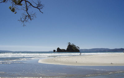 Scenic view of beach against clear blue sky