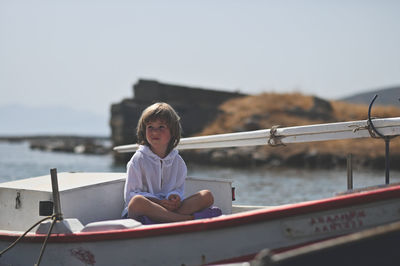 Full length of woman sitting on boat against sky