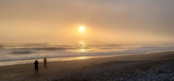 Scenic view of beach against sky during sunset