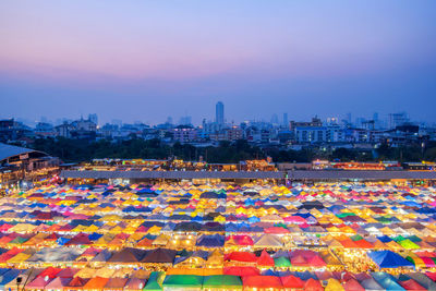 High angle view of illuminated buildings in city at sunset