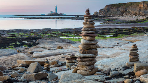 Stack of stones on beach against sky