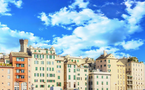 Low angle view of buildings against cloudy sky