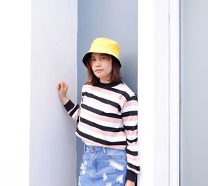 Portrait of smiling woman standing against wall