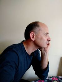 Portrait of man sitting against wall