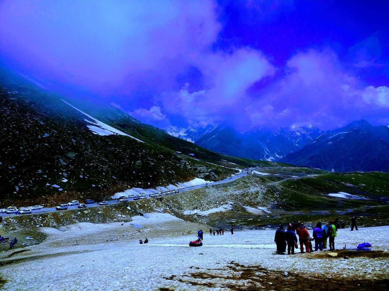 PEOPLE ON SNOWCAPPED MOUNTAIN AGAINST CLOUDY SKY