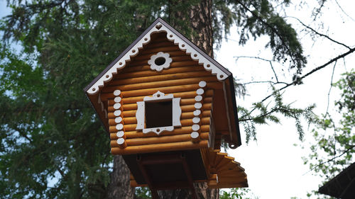 Low angle view of birdhouse on tree against building