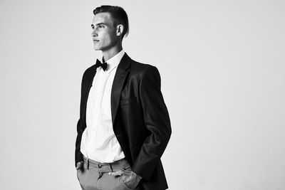 Young man looking away against white background