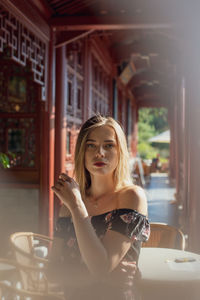 Portrait of woman drinking glass in restaurant