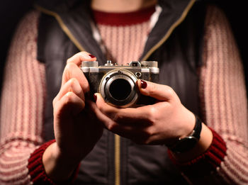 Midsection of woman using analog camera