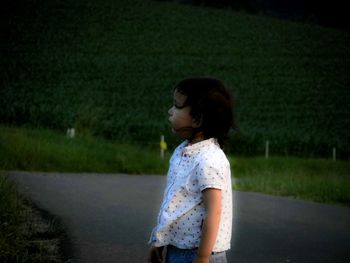 Woman looking away while standing on field