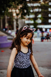 Portrait of a teenage girl standing on street in city