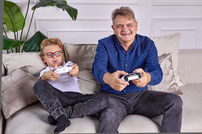 Portrait of smiling man holding sofa at home