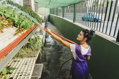 Female owner watering plants at nursery