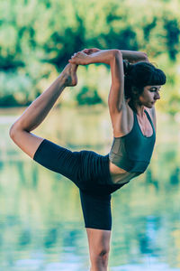 Yoga woman by the water. dancer pose