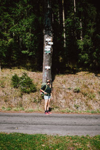 Woman standing on footpath in forest