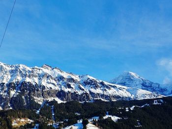 Scenic view of snowcapped mountains against blue sky