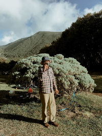 Man standing by tree against sky