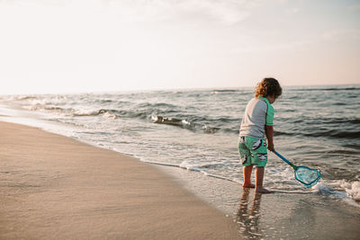 Boy on beach at sunrise