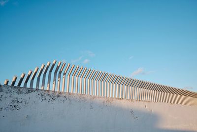 Low angle view of snow covered land against blue sky