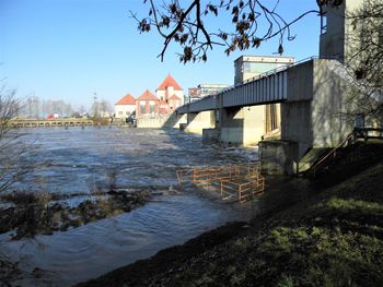 Houses by river against clear sky