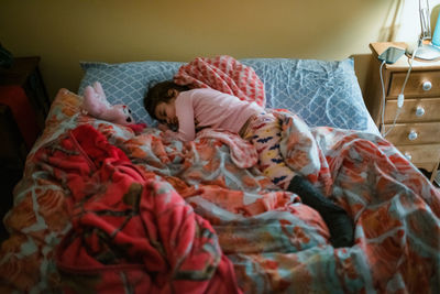 Boy sleeping on bed at home