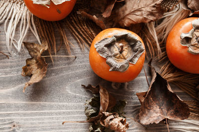 Pumpkins on dry leaves on table