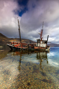 Boat moored on sea against sky