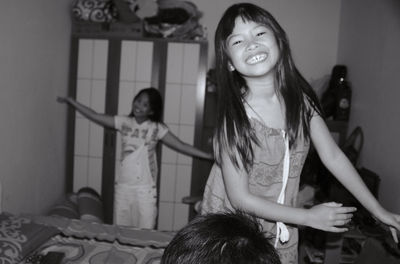 Portrait of smiling girls playing at home