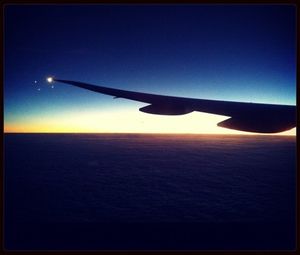 Cropped image of airplane flying over cloudscape