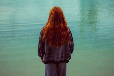 Rear view of woman standing against sea