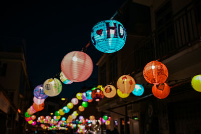 Low angle view of illuminated lanterns hanging at night