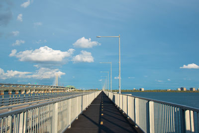 Bridge over calm sea against sky