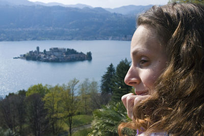 Close-up of woman against lake orta during sunny day