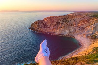 Low section of person on mountain during sunset