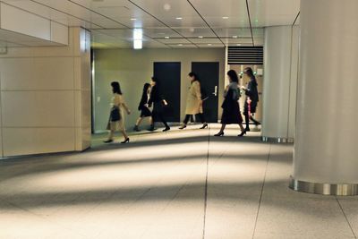 People walking in corridor of building