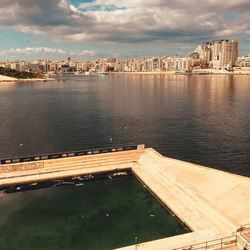 High angle view of river by buildings against sky