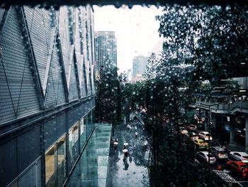 Wet street amidst buildings in city during rainy season