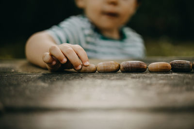 Close up child playing with acorns