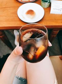 Midsection of woman holding drink on table