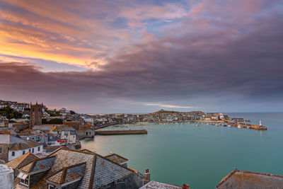 High angle view of buildings by sea against sky