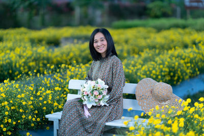 Portrait of a smiling young woman standing on field