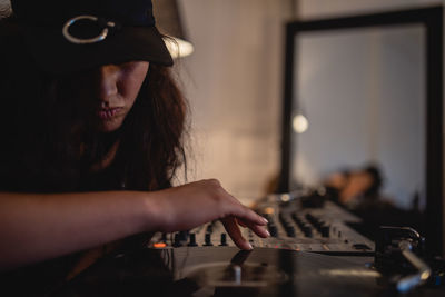 Close-up of fashionable young woman playing music at home