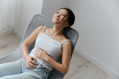 Portrait of young woman sitting at home