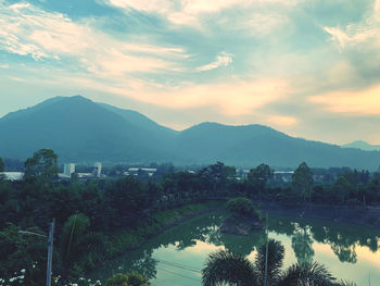 Scenic view of trees and buildings against sky during sunset